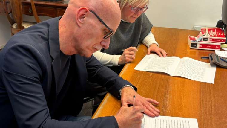 Arturo Nora (presidente Coopattiva) ed Erika Ansaloni (ex presidente Mediando) siglano l'atto di fusione per incorporazione